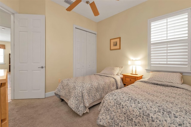 carpeted bedroom with ceiling fan and a closet