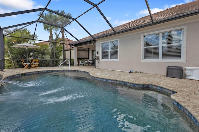 outdoor pool featuring glass enclosure and a patio area