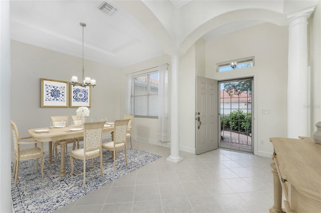 foyer featuring a notable chandelier, ornate columns, and light tile patterned floors