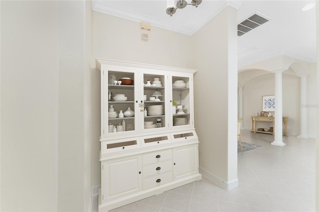 hall featuring decorative columns and ornamental molding