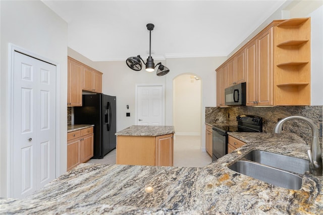 kitchen featuring open shelves, a sink, arched walkways, a kitchen island, and black appliances