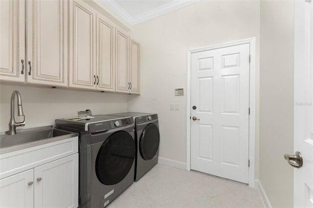 laundry room with washing machine and clothes dryer, sink, cabinets, light tile patterned floors, and ornamental molding