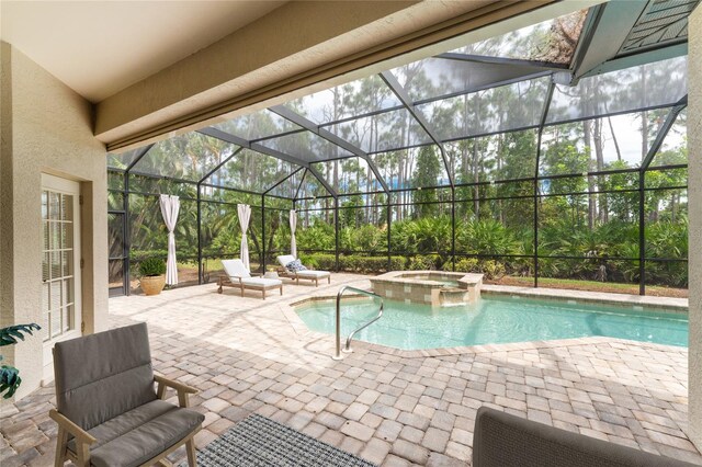 view of pool featuring glass enclosure, a patio, and a pool with connected hot tub