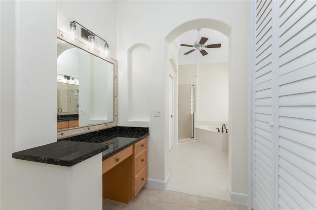 full bath featuring tile patterned floors, a ceiling fan, a shower stall, a garden tub, and vanity