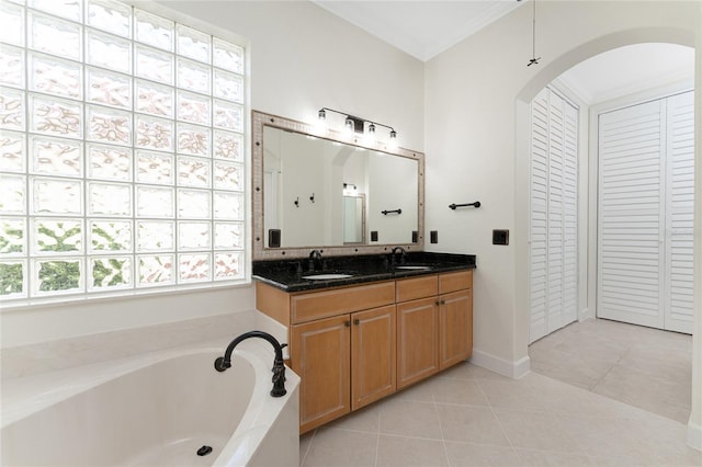 bathroom featuring tile patterned flooring, vanity, a bath, and ornamental molding