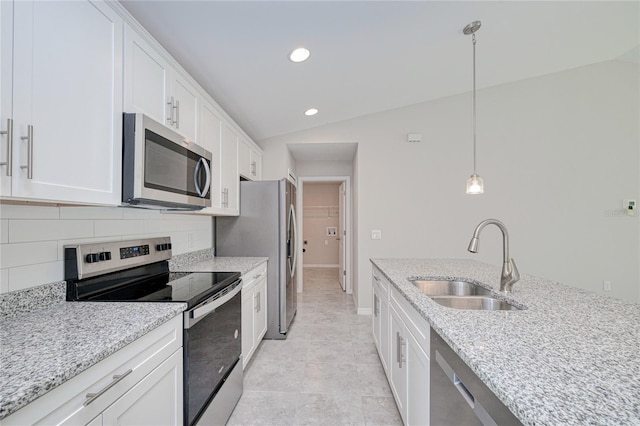 kitchen with pendant lighting, stainless steel appliances, vaulted ceiling, and sink