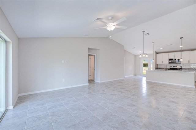 unfurnished living room with light tile patterned flooring, ceiling fan with notable chandelier, sink, and vaulted ceiling