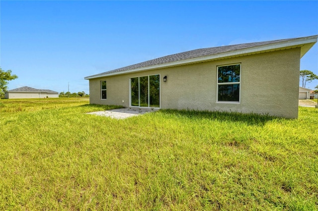 back of house featuring a lawn and a patio area