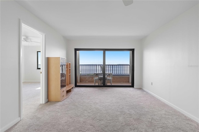 carpeted spare room with ceiling fan