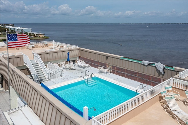 view of pool with a water view and a patio area