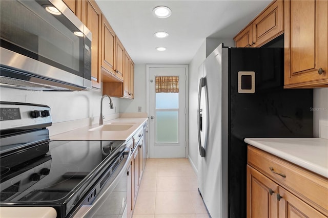 kitchen featuring appliances with stainless steel finishes, sink, and light tile patterned floors