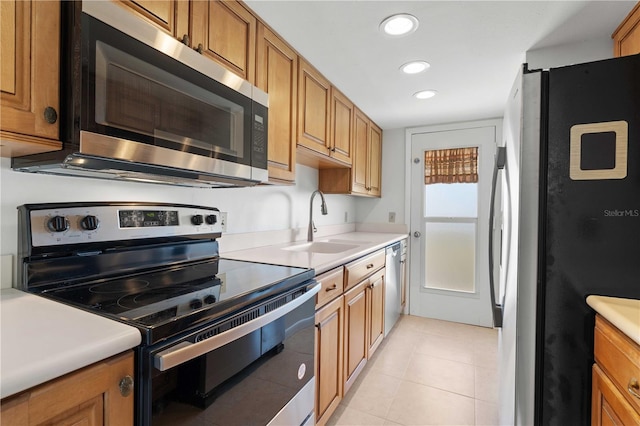 kitchen featuring appliances with stainless steel finishes, light tile patterned flooring, and sink