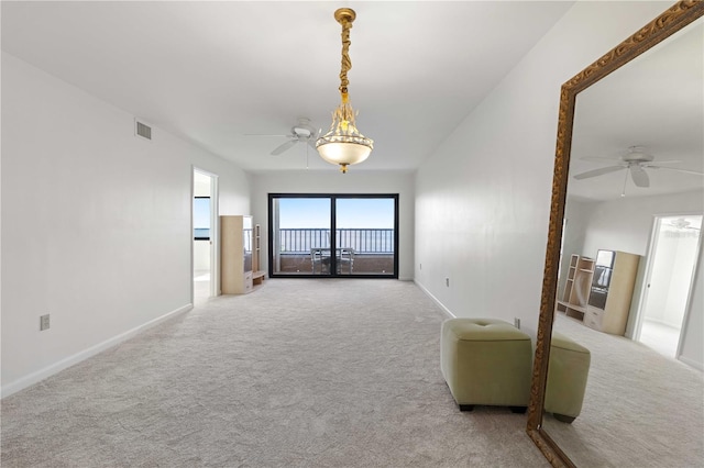 unfurnished living room featuring light carpet and ceiling fan