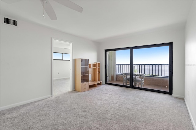 interior space with ceiling fan, light carpet, and access to outside