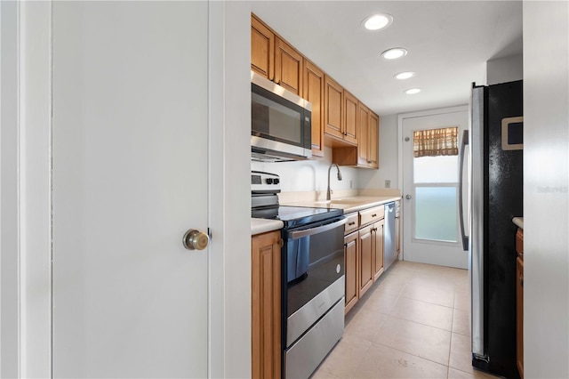 kitchen featuring sink, light tile patterned floors, and stainless steel appliances