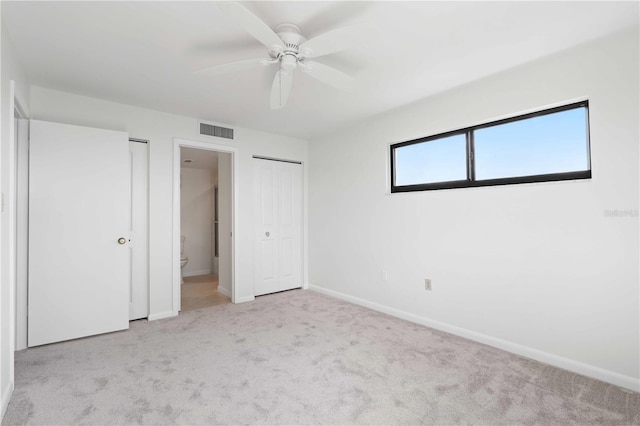 unfurnished bedroom with ensuite bath, light carpet, and ceiling fan