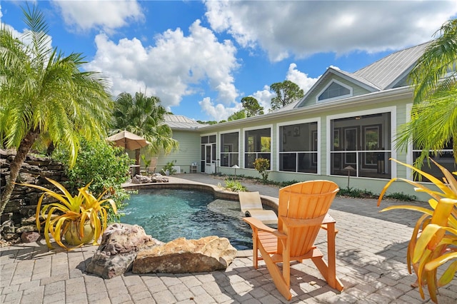 view of swimming pool featuring a sunroom and a patio area