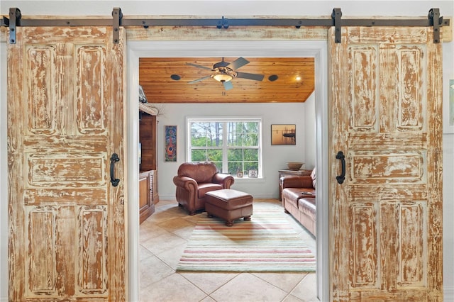 living area with ceiling fan and light tile patterned floors