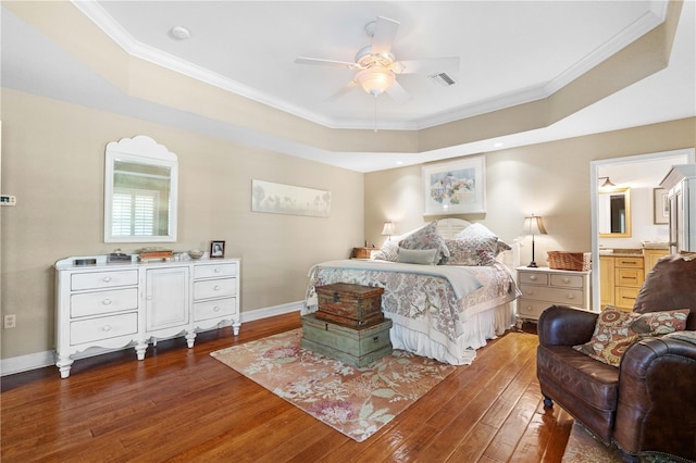 bedroom with ceiling fan, connected bathroom, dark hardwood / wood-style floors, and ornamental molding