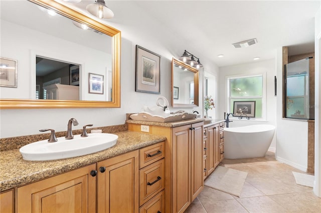 bathroom featuring tile patterned flooring, a tub to relax in, and vanity