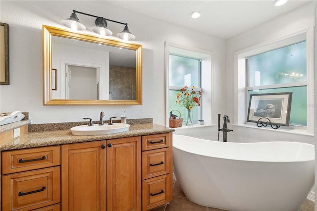 bathroom with a bathtub, tile patterned flooring, and vanity