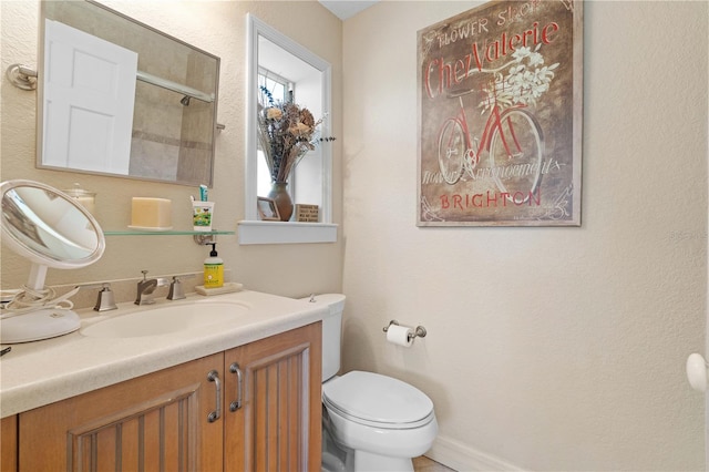 bathroom featuring vanity, a shower with shower door, and toilet