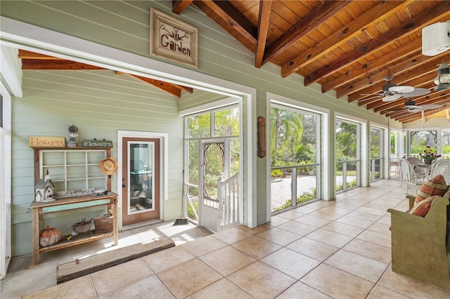 sunroom featuring lofted ceiling with beams, ceiling fan, and wooden ceiling