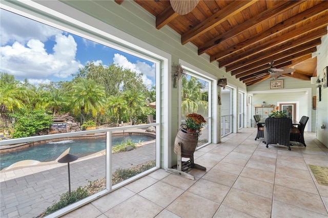 unfurnished sunroom featuring vaulted ceiling with beams, ceiling fan, and wooden ceiling