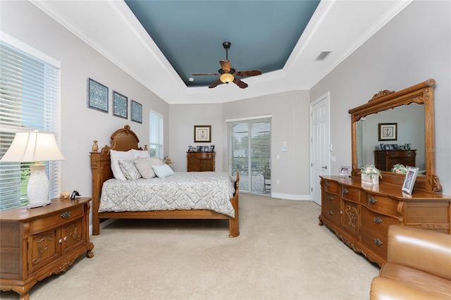 bedroom with ceiling fan, access to exterior, ornamental molding, a tray ceiling, and light colored carpet