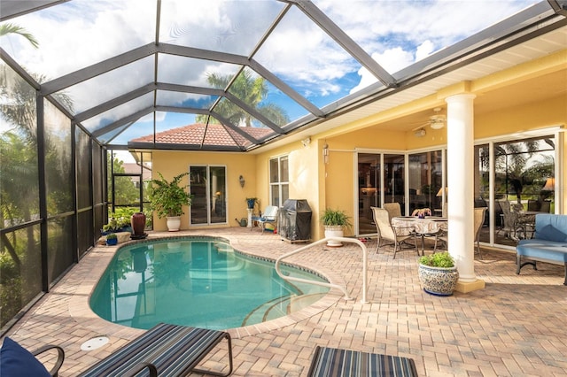 view of pool with ceiling fan, a lanai, a patio, and grilling area