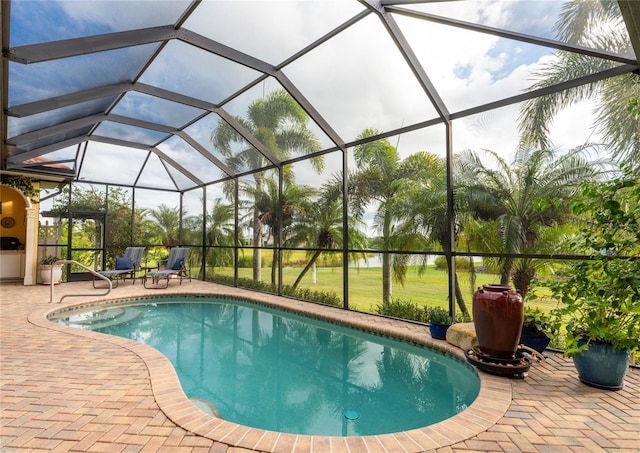 view of pool with glass enclosure and a patio