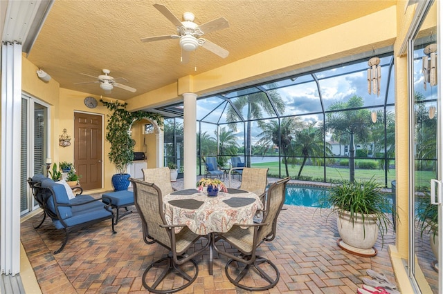 sunroom / solarium with ceiling fan and a swimming pool