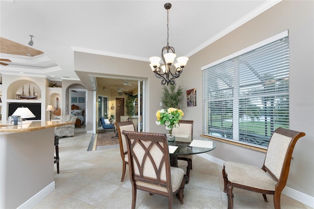 tiled dining space with ceiling fan with notable chandelier, built in features, and crown molding