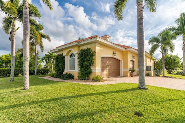 mediterranean / spanish house with a front yard and a garage