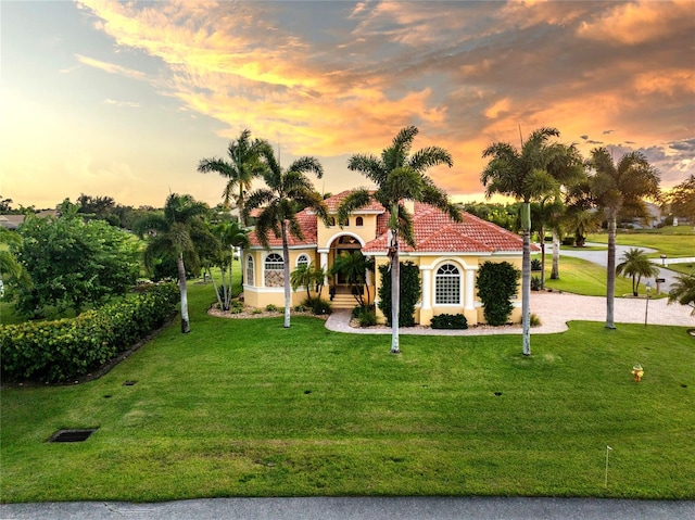 mediterranean / spanish-style house with a lawn