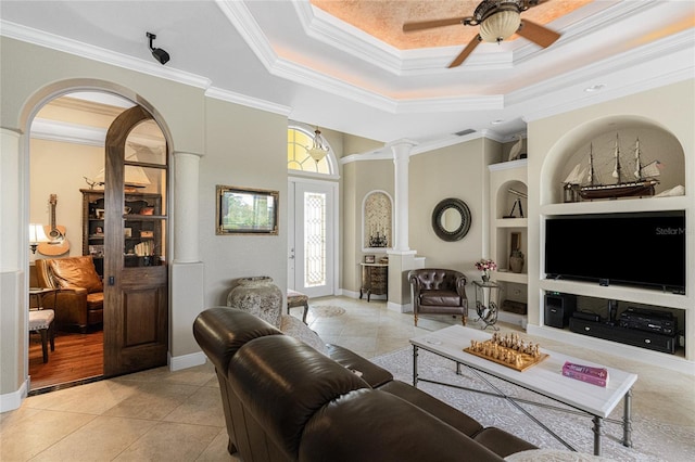 living room with light tile patterned floors, crown molding, built in features, and ceiling fan