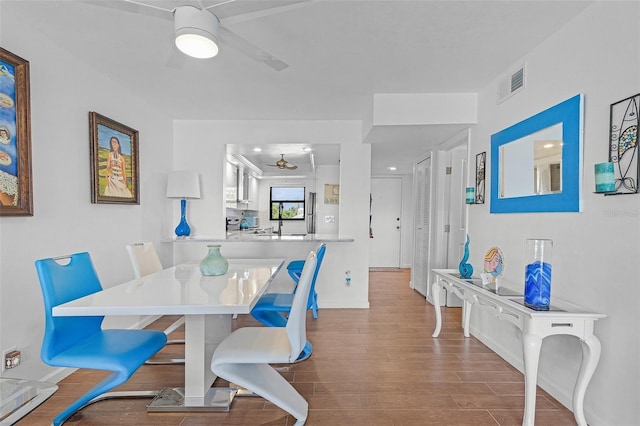 dining space featuring baseboards, ceiling fan, visible vents, and wood finished floors