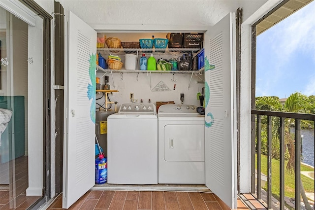 washroom featuring washing machine and clothes dryer, laundry area, wood finish floors, and a wealth of natural light