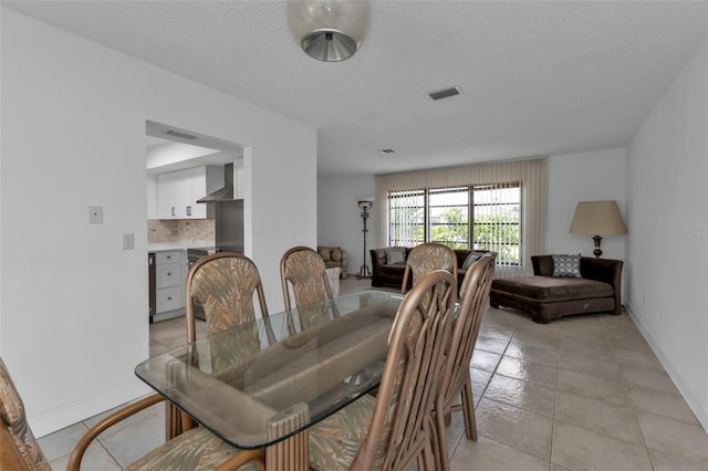 tiled dining space featuring a textured ceiling