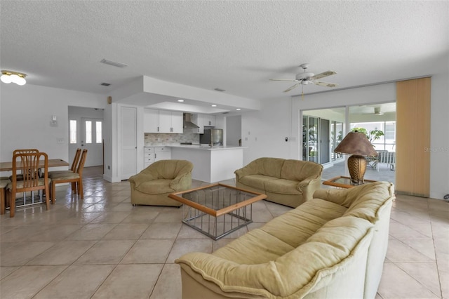 living room featuring ceiling fan, a textured ceiling, and light tile patterned floors