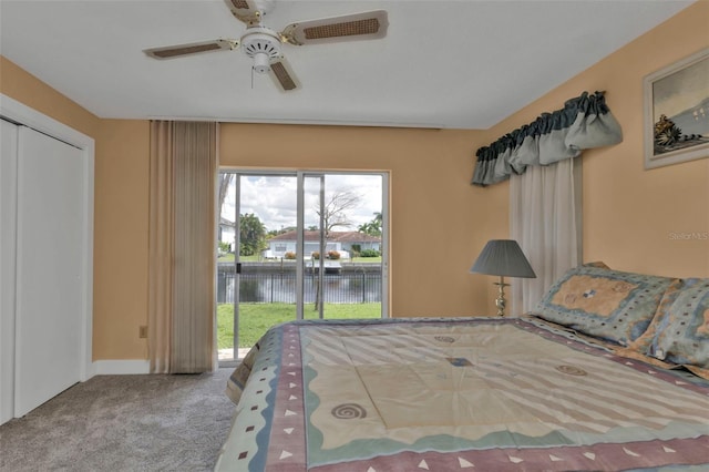 unfurnished bedroom featuring multiple windows, a water view, ceiling fan, and access to exterior