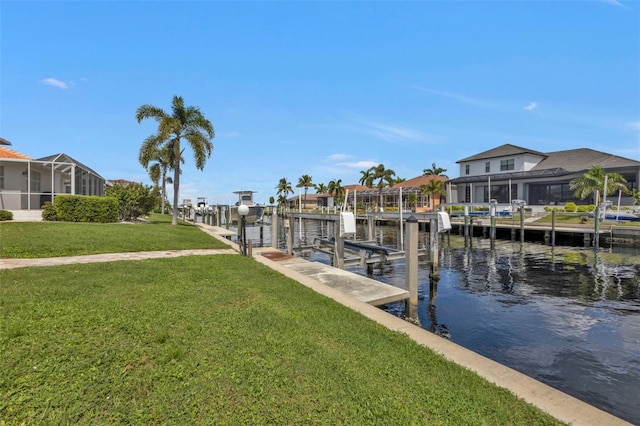 view of dock with a lanai, a water view, and a lawn