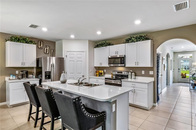 kitchen featuring appliances with stainless steel finishes, sink, white cabinetry, and an island with sink