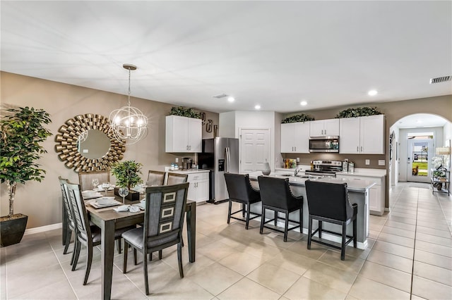 tiled dining area featuring an inviting chandelier