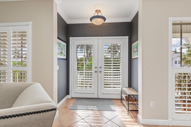 doorway featuring light tile patterned floors, ornamental molding, and french doors