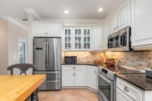 kitchen with ornamental molding, backsplash, white cabinetry, and appliances with stainless steel finishes