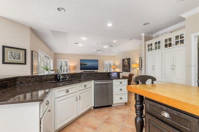 kitchen with stainless steel dishwasher, ceiling fan, sink, white cabinetry, and light tile patterned flooring