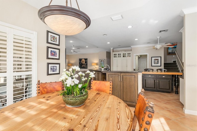 dining space with sink, ceiling fan, ornamental molding, and light tile patterned flooring