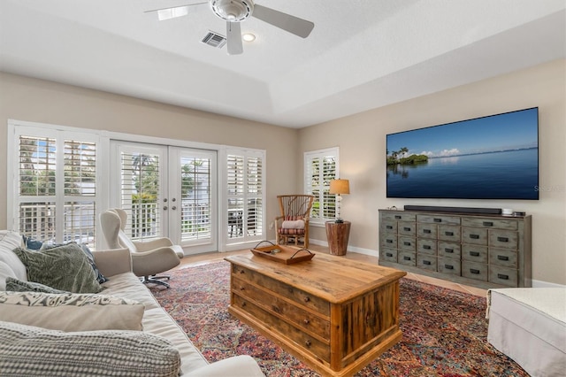 living room featuring ceiling fan and french doors