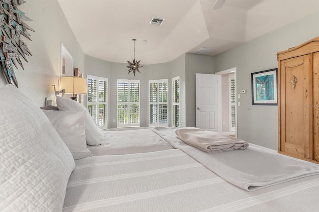 bedroom featuring ceiling fan with notable chandelier